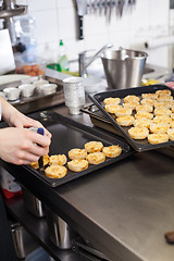 Image showing Chef preparing desserts removing them from moulds