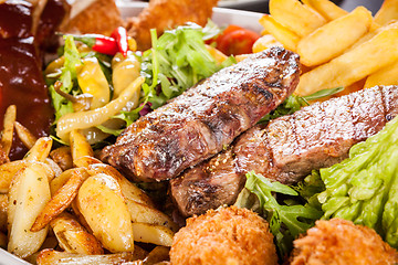 Image showing Platter of mixed meats, salad and French fries