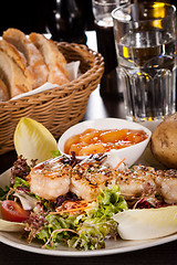 Image showing Grilled prawns with endive salad and jacket potato