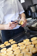 Image showing Chef preparing desserts removing them from moulds