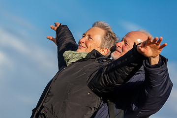 Image showing Elderly couple embracing and celebrating the sun