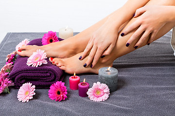 Image showing Bare feet of a woman surrounded by flowers