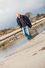 Image showing Elderly energetic man running along a beach