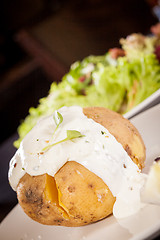 Image showing Baked jacket potato with sour cream sauce