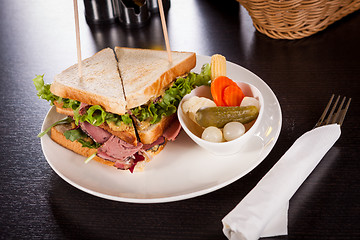 Image showing Delicious pastrami club sandwich and pickles