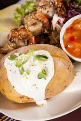 Image showing Grilled prawns with endive salad and jacket potato