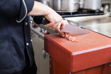 Image showing Chef or butcher dicing meat