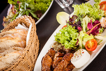 Image showing grilled beef stripes fresh salad and goat cheese