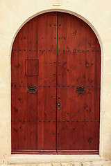 Image showing Arched wooden door in a stone wall