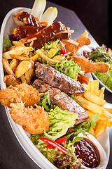 Image showing Platter of mixed meats, salad and French fries