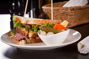 Image showing Delicious pastrami club sandwich and pickles