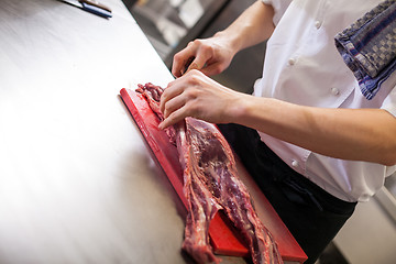 Image showing Chef or butcher dicing meat