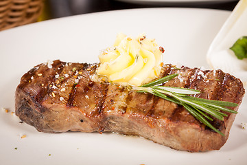 Image showing Grilled beef steak topped with butter and rosemary