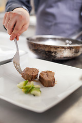 Image showing Chef plating up food in a restaurant