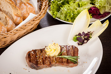 Image showing Grilled beef steak topped with butter and rosemary