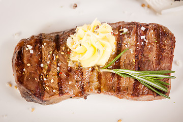 Image showing Grilled beef steak topped with butter and rosemary