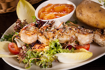 Image showing Grilled prawns with endive salad and jacket potato