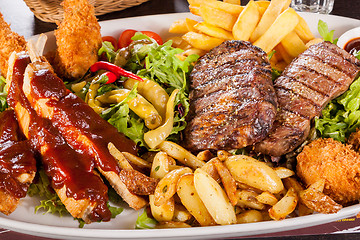 Image showing Platter of mixed meats, salad and French fries