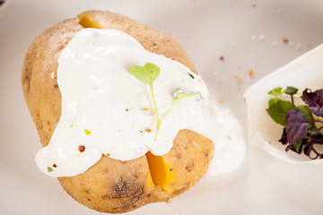 Image showing Baked jacket potato with sour cream sauce