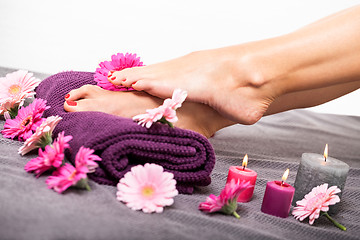 Image showing Bare feet of a woman surrounded by flowers