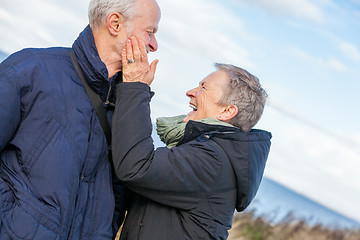 Image showing Elderly couple embracing and celebrating the sun