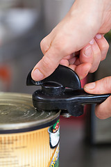 Image showing Man opening a tin of canned food