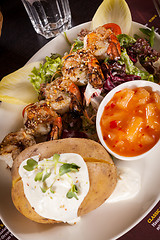 Image showing Grilled prawns with endive salad and jacket potato