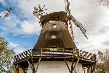 Image showing Traditional wooden windmill in a lush garden