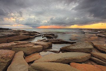 Image showing Sun rays, rocks and storm clouds