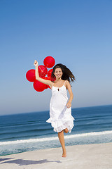 Image showing Beautiful girl running with red ballons