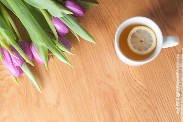Image showing Violet tulips on the wood and tea, top view