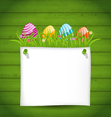 Image showing  Easter colorful eggs in green grass with empty paper card for y