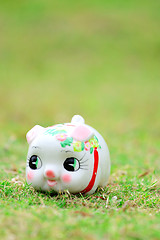 Image showing Chinese style piggy bank on green grass
