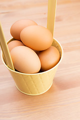 Image showing Brown egg in bucket