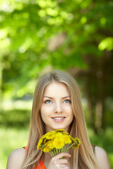 Image showing Spring girl lying on the field of dandelions