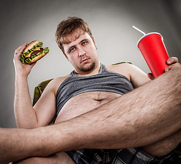 Image showing Fat man eating hamburger