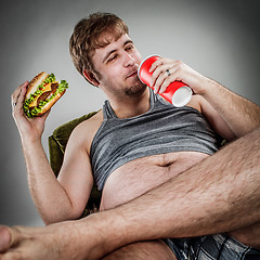 Image showing Fat man eating hamburger