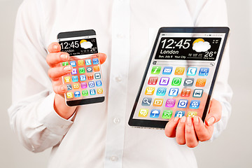 Image showing Smartphone and tablet with transparent screen in human hands.