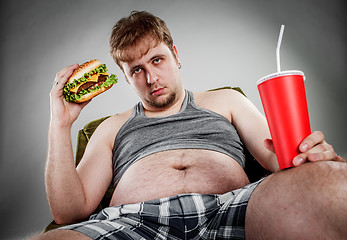 Image showing Fat man eating hamburger