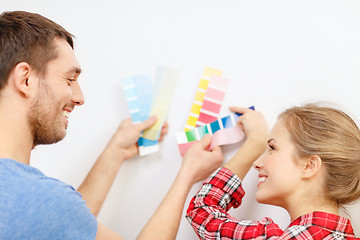 Image showing smiling couple looking at color samples at home