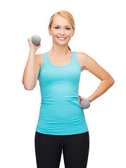 Image showing young sporty woman with light dumbbells