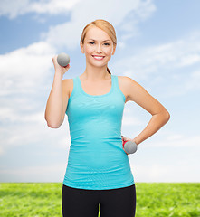 Image showing young sporty woman with light dumbbells