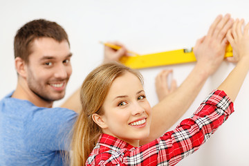 Image showing couple building using spirit level to measure