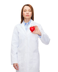 Image showing serious female doctor with heart