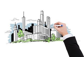 Image showing close up of businessman drawing city sketch