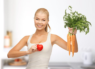 Image showing woman holding heart symbol and carrots