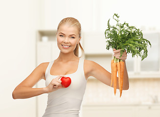 Image showing woman holding heart symbol and carrots