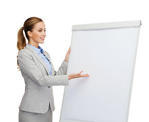 Image showing smiling businesswoman standing next to flipboard