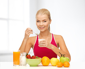 Image showing young woman eating healthy breakfast