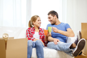 Image showing smiling couple relaxing on sofa in new home